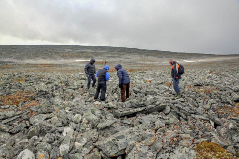 Øystein Rønning Andersen measuring the exact find spot of the sword together with the reindeer hunters. Detectorist Egil Bjørnsgård (right) has started checking for signals in the scree. Photo: Espen Finstad, Secrets of the Ice